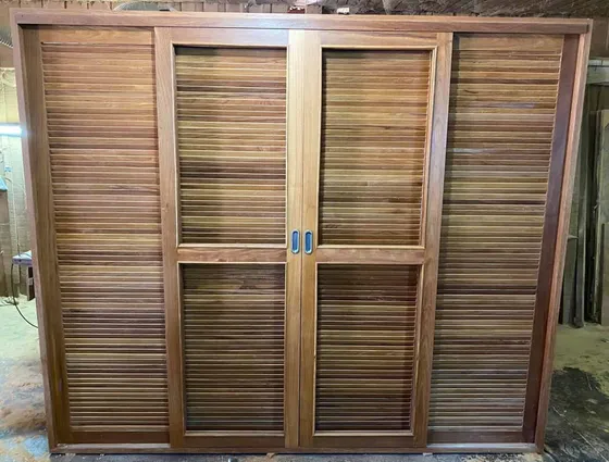 Porta de veneziana e vidro em Cumaru fabricada na marcenaria da Wood Fort